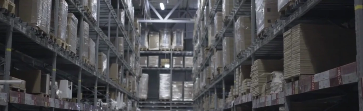 Entrepôt logistique avec rayonnages industriels remplis de palettes et cartons – stockage et organisation de solutions d’affichage TELNALINE