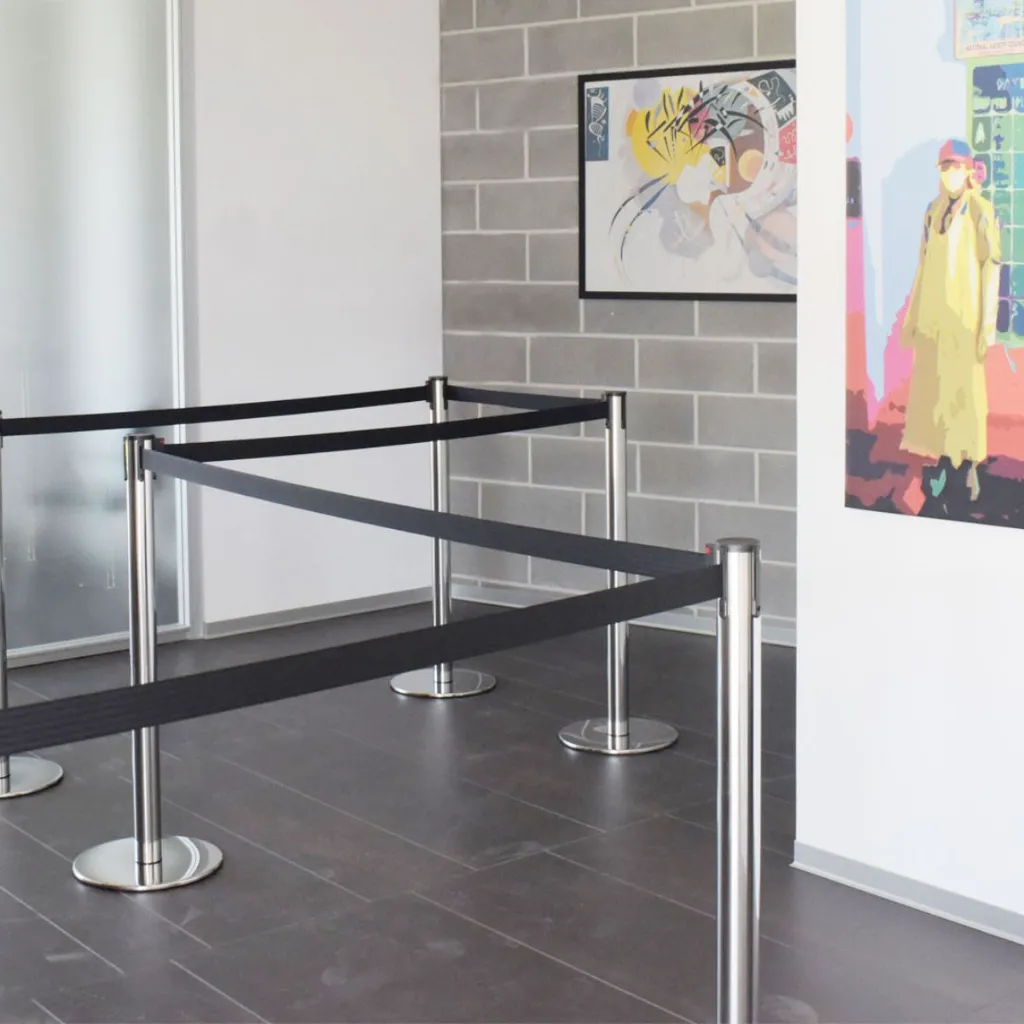 Poteaux de guidage acier poli avec sangle noire en espace professionnel TELNALINE