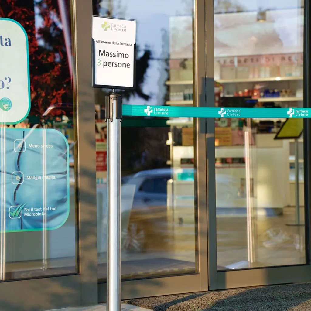 Porte affiche A4 installé à l’entrée d’un magasin sur poteau de délimitation TELNALINE