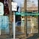 Porte affiche A4 installé à l’entrée d’un magasin sur poteau de délimitation TELNALINE